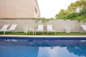 a group of chairs sitting next to a swimming pool at Hotel Morlans Suites - Adults Only in Paguera