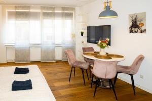 a living room with a table and chairs and a tv at Cozy apartment in central location in Wuppertal