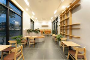 a restaurant with wooden tables and chairs and windows at Ocean Hotel in Sầm Sơn