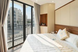 a bedroom with a large bed and a balcony at Ocean Hotel in Sầm Sơn
