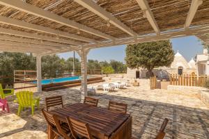 a patio with a table and chairs and a pool at Trullo Aia Antica in Ceglie Messapica