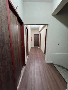 an empty hallway with wood floors and a door at Liv Stay in Brasília