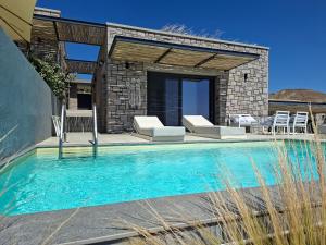 a swimming pool with chairs and a house at Villa la Vago in Agios Ioannis Kaspaka