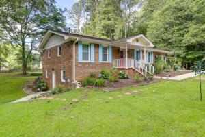 Una casa de ladrillo con césped delante. en 5 Mi to Trilith Studios Apt with Furnished Pergola, en Fayetteville