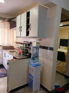a kitchen with white cabinets and a counter top at Kitengela two bedroom stays in Kitengela  +8 photos