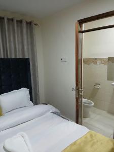 a bedroom with a bed and a bathroom with a toilet at Kitengela two bedroom stays in Kitengela 