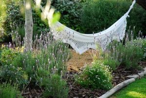 a white hammock in a garden with flowers at Quinta da Lua in Tavira