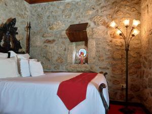 ein Schlafzimmer mit einem Bett in einer Steinwand in der Unterkunft Casas do Rio in Cossourado