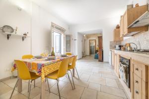a kitchen with a table and yellow chairs in a kitchen at Trullo Aia Antica in Ceglie Messapica