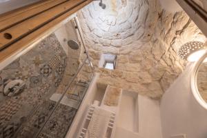 a bathroom with a stone wall and a shower at Trullo Aia Antica in Ceglie Messapica +26 photos