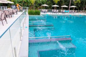 a swimming pool with a person in the water at Hotel Vilage Inn All Inclusive Poços de Caldas By Nacional Inn in Poços de Caldas