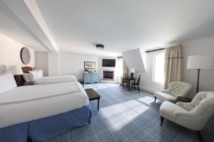 a hotel room with two beds and a chair at Chatham Bars Inn in Chatham