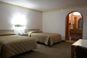 a hotel room with two beds and a mirror at The Flamingo Motel San Jose in San Jose