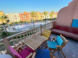 a balcony with chairs and a bench and a pool at Porto Matrouh in Marsa Matruh