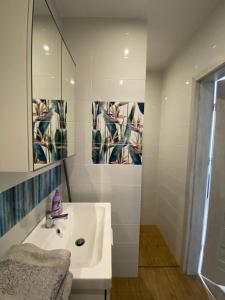 a white bathroom with a sink and a mirror at Lawendowy Gościniec II in Białogóra +20 photos