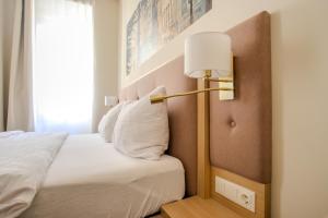 a bedroom with a bed with a lamp on it at Boutique Hotel Parklane - Newly Renovated in Vienna