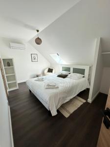 a white bedroom with a large white bed in it at La grange de La Contie in Perpezac-le-Blanc