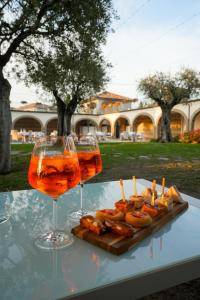 a table with two glasses of wine and a tray of food at Agriturismo La Vecchia Torre in San Nicola Manfredi