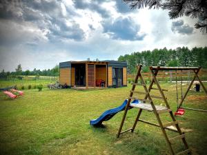 una piccola casa con altalena e parco giochi di Cisy Resort II-bon turystyczny,ogrodzony teren na wyłączność,150 m od jeziora a Krzywe