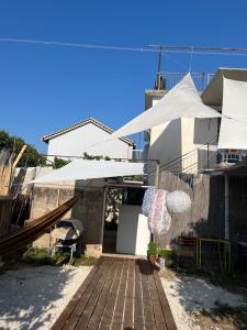 a patio with white umbrellas on a house at Himara Hostel in Himare