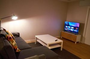 a living room with a couch and a flat screen tv at Malladoura Passive House in Porriño