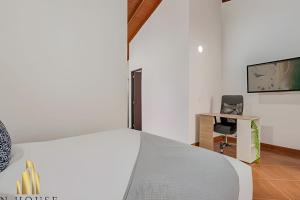 a bedroom with a bed and a desk and a tv at Aria Living 500 - Modern with Private Terrace in Guayaquil