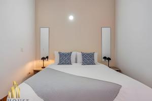 a bedroom with a large white bed with blue pillows at Aria Living 500 - Modern with Private Terrace in Guayaquil