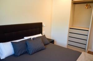 a bedroom with a bed with blue and white pillows at Malladoura Passive House in Porriño