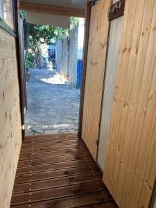a hallway leading into a building with wooden doors at Himara Hostel in Himare
