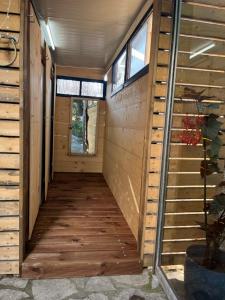 a hallway of a house with wooden floors and windows at Himara Hostel in Himare