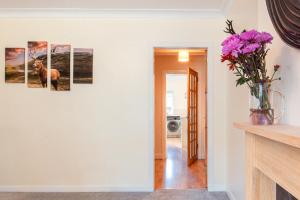 a room with three paintings on the wall at Stag's View Lodge in Edinburgh