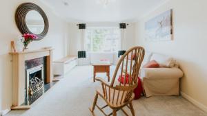 a living room with a fireplace and a chair at Stag's View Lodge in Edinburgh +17 photos