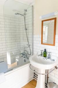 a bathroom with a sink and a shower at Historic 2 bed gatehouse in private parkland in Brockenhurst +11 photos