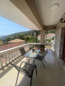 a patio with a table and chairs on a balcony at Ionian Escape in Ayia Evfimia
