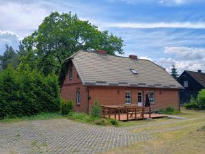 a brick house with a picnic table in front of it at Klimatyczne Siedlisko in Piece