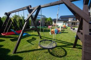 a swing set in a yard with a playground at Apartament Perfect House Morski 8 in Władysławowo