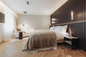 ein Schlafzimmer mit einem großen Bett und einer Holzwand in der Unterkunft Gentle Hide Designhotel in Salzburg