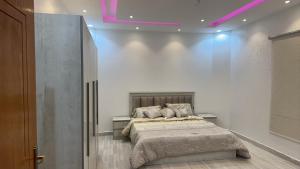 a bedroom with a bed and a purple lighting at فيلا بحوش خاص in Al Baha