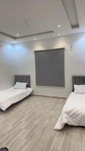 a room with two beds and a projection screen at فيلا بحوش خاص in Al Baha