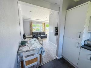 a kitchen and living room with a table and a couch at Charming Chalet On A Fantastic Holiday Park In Lowestoft Ref 12077B in Lowestoft