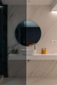 a bathroom with a sink and a mirror at Next Level by Seaward Suites in Villajoyosa