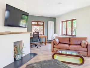 a living room with a couch and a fireplace at Barn Cottage in Wick
