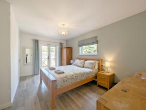 a bedroom with a large bed and a window at Barn Cottage in Wick