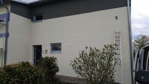 a white building with a ladder on the side of it at Gästehaus Stüpfert in Grub am Forst