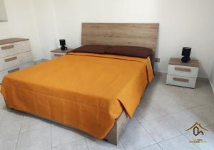 a bedroom with a bed with an orange bedspread at Maia Etna Sea Guest House in Riposto