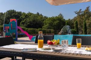 a table with a bowl of fruit next to a pool at Villa Rosanna Siena Authentic Retreat in Siena