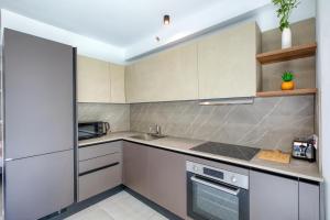 a kitchen with white cabinets and a sink at Luxury Apartment Heart of St Julians Sleeps 5 in San Pawl il Bahar