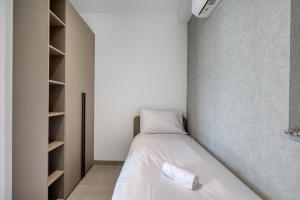 a small room with a bed and a book shelf at Luxury Apartment Heart of St Julians Sleeps 5 in San Pawl il Bahar +23 photos