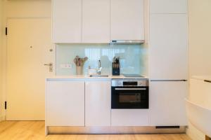 a kitchen with white cabinets and a stove at Studio w/ Balcony, Pool & Gym | Antas by Host Wise in Porto