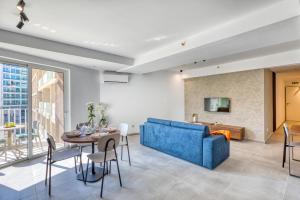 a living room with a blue couch and a table at Luxury Apartment Heart of St Julians Sleeps 5 in San Pawl il Bahar